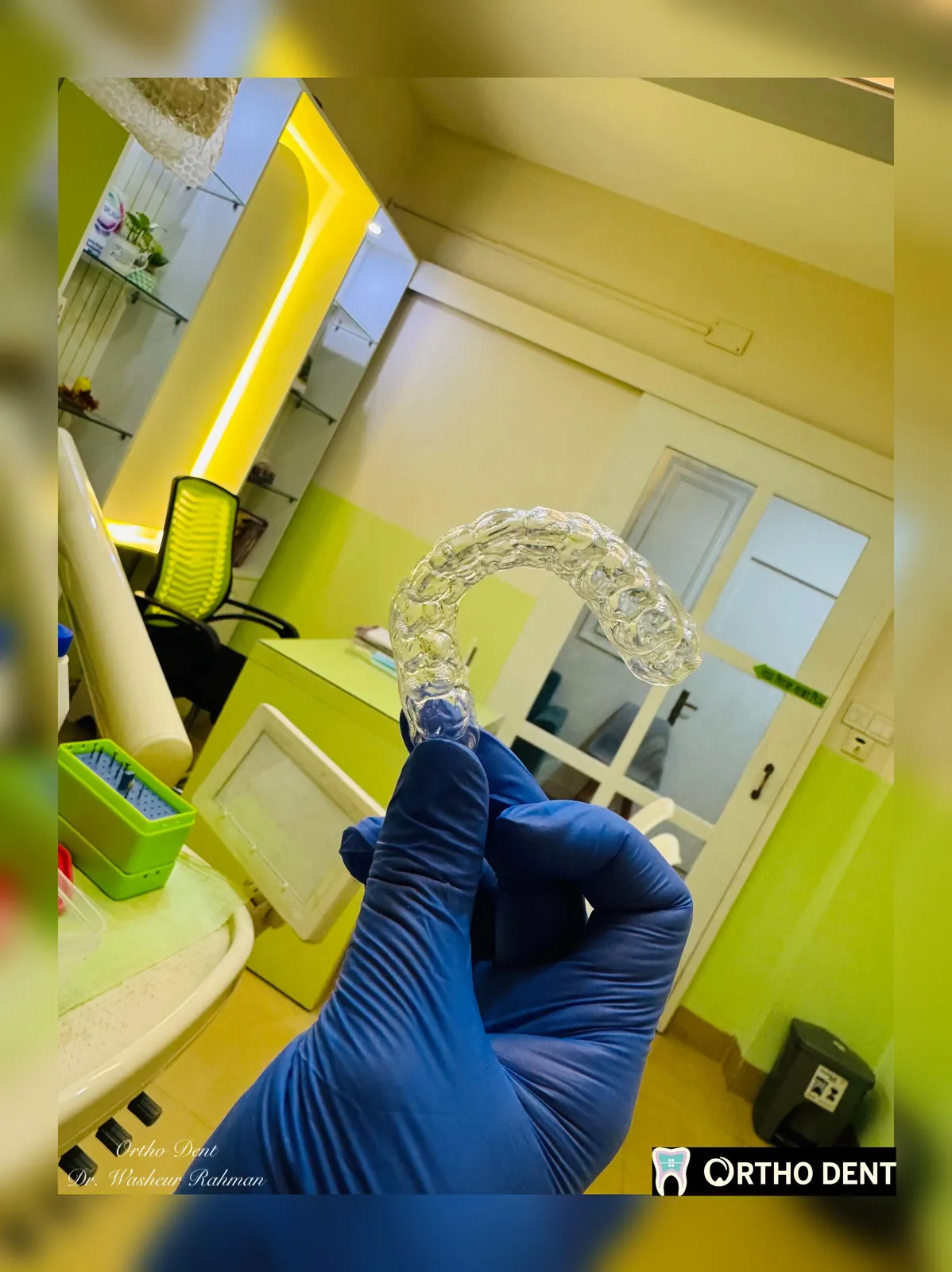 A clear aligner tray held beside a model of the teeth